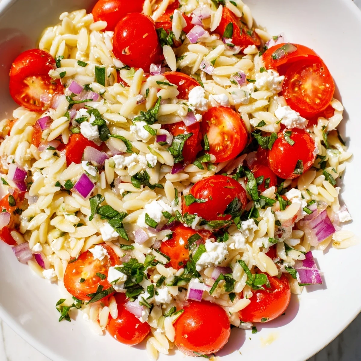 Creamy feta crumbles mingle with bright cherry tomatoes in this delicious Tomato Feta Orzo for lunch.