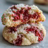 A close-up view highlights the tender texture and jammy raspberry pieces inside these Soft Chewy Raspberry Sugar Cookies.