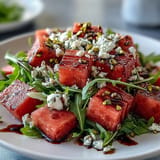 Refreshing watermelon feta arugula salad with vibrant balsamic glaze ready to serve.