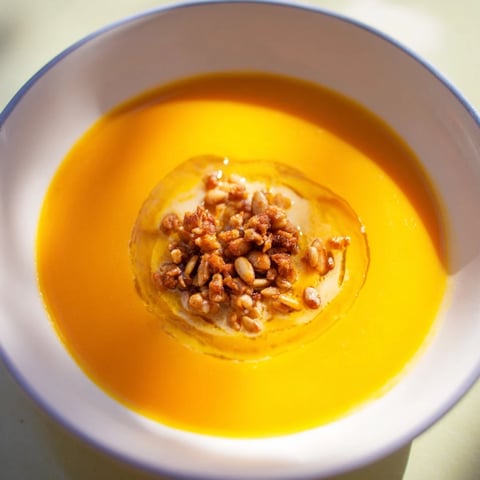 A steaming bowl of Creamy Roasted Pumpkin Soup with toasted seeds, ready to savor.