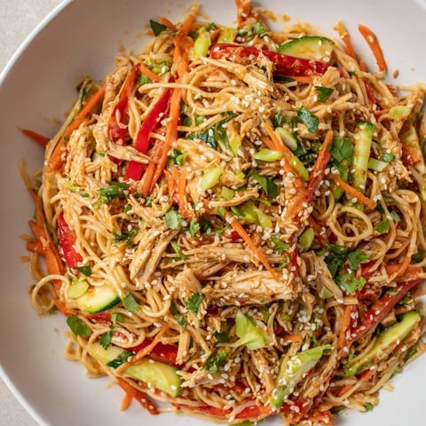 Chilled Chicken Noodle Salad: A vibrant bowl showcasing colorful veggies, tender chicken, and sesame dressing.