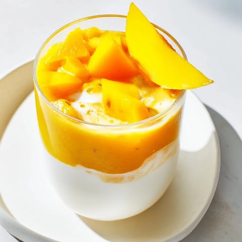 A layered Tropical Sunset Smoothie with vibrant colors, perfect for a summer breakfast treat.