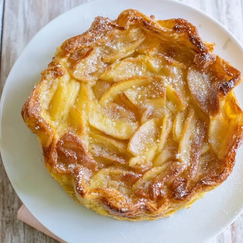 A close-up of flaky, buttery homemade apple turnover pastries, perfect for a cozy dessert or snack.