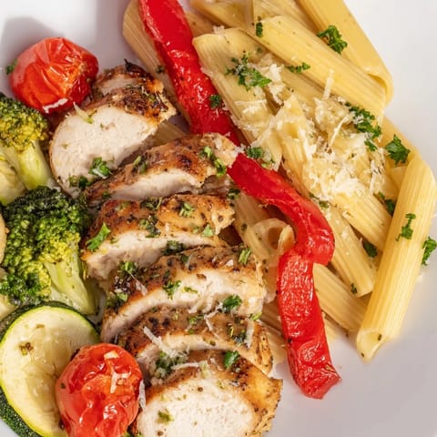Juicy garlic-herb chicken roasted with red bell peppers, zucchini, and cherry tomatoes tossed with penne pasta in a light, savory sauce.