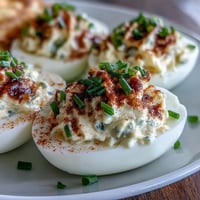 Classic Deviled Eggs with Paprika and Chives: Creamy, tangy yolk filling in tender egg whites, topped with smoky paprika and fresh chives.