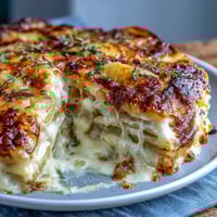 Creamy scalloped potatoes with Gruyere cheese, baked until golden and bubbling, make a luxurious side dish for holiday dinners.
